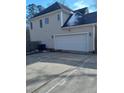 A spacious two-car garage is attached to the home, featuring a light colored door and exterior lights at 1508 Westfall Cir, Sanford, NC 27330