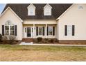 Close up of charming home with classic black shutters, covered porch, and landscaped front yard at 302 Mar Joy Dr, Dunn, NC 28334