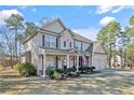 Charming two-story home with a covered front porch, manicured lawn, and attached two car garage at 968 Coachman Way, Sanford, NC 27332