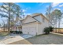 Side view of a charming two-story home with an attached two car garage and manicured lawn at 968 Coachman Way, Sanford, NC 27332