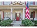 Inviting front porch with rocking chairs, American flag, and well-maintained landscaping at 968 Coachman Way, Sanford, NC 27332