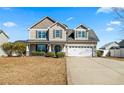 Charming two-story home with a well-manicured lawn and attached two-car garage at 219 Regimental Dr, Cameron, NC 28326