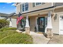 Inviting covered front porch with stone accents, swing, and well-maintained landscaping at 219 Regimental Dr, Cameron, NC 28326