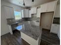 Well-lit kitchen with granite countertops, white cabinets, stainless steel appliances, and a functional island at 22 Peach Orchard (Lot 1) Ln, Lillington, NC 27546