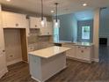 Open kitchen with island, granite countertops, stainless sink and modern pendant lighting at 62 Peach Orchard (Lot 3) Ln, Lillington, NC 27546