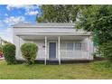Inviting home featuring a classic covered front porch, gray siding, and a well-kept lawn at 1512 Pender St, Raleigh, NC 27610