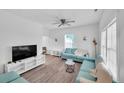 Bright living room with new laminate flooring, a ceiling fan, and comfortable blue sofas at 1512 Pender St, Raleigh, NC 27610