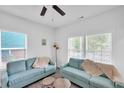 Bright living room featuring two light blue sofas, hardwood flooring, and large windows at 1512 Pender St, Raleigh, NC 27610