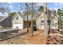 View of the home's front exterior, showing stone details, driveway, and mature trees at 45 Cutter Cir, Sanford, NC 27332