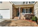 Inviting front entryway showcasing stone accents, a cozy porch, and a well-maintained two-car garage at 45 Cutter Cir, Sanford, NC 27332