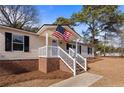 Inviting front porch with white railings and an American flag, adding a touch of patriotism at 14 Brafford Estates Dr, Cameron, NC 28326