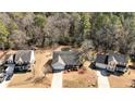 Aerial view of three houses in a residential neighborhood showcasing their roofs and surrounding wooded landscape at 140 Cobblestone Dr, Spring Lake, NC 28390