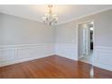 Dining room featuring hardwood floors, elegant wainscoting, and a classic chandelier at 25 Trenton Place, Cameron, NC 28326