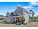 Side view of two-story home featuring well-maintained lawn, landscaping, and a two-car garage at 151 New Castle Ln, Spring Lake, NC 28390