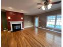 Spacious living room featuring a fireplace, hardwood floors, and ceiling fan at 210 E E St, Erwin, NC 28339