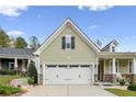 Two car garage with a well manicured lawn and a charming front porch with rocking chairs at 10 Glenside Ct, Spring Lake, NC 28390