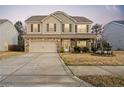 Charming two-story home with a stone and vinyl facade, covered porch, two-car garage, and landscaped yard at 190 National Dr, Clayton, NC 27527