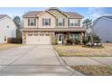 Charming two-story home with a stone and vinyl facade, covered porch, two-car garage, and landscaped yard at 190 National Dr, Clayton, NC 27527