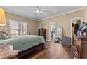 A nicely decorated bedroom with hardwood floors, ceiling fan, and access to ensuite bathroom at 7053 Maple Cir, Sanford, NC 27332