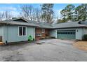 Light blue single story house with attached garage, brick accents, and tidy landscaping at 95 Fairway Ln, Sanford, NC 27332