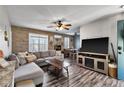 Comfortable living room featuring a brick accent wall, plush seating, and modern ceiling fan at 4901 North Pointe, Sanford, NC 27332