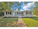Charming single-story home with a brick walkway, lush lawn and blue front door at 500 S 13Th St, Erwin, NC 28339