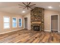 Inviting living room featuring wood floors, a stone fireplace, and ample natural light from large windows at 525 Sanctuary Trl, Cameron, NC 28326