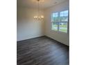 Dining room with wood floors, a modern chandelier, and a large window overlooking the outdoors at 81 Reece Dr, Sanford, NC 27332