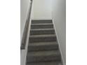 Carpeted staircase with white walls and wood railing leads to the next level at 81 Reece Dr, Sanford, NC 27332