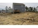 Exterior rear view of home with a wooden deck, sliding glass doors and large backyard at 932 Allstar Ave, Cameron, NC 28326