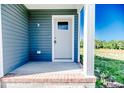 Welcoming front entryway with gray siding, a brick step, and a white-trimmed door at 932 Allstar Ave, Cameron, NC 28326