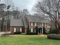 Two-story brick home featuring manicured landscaping, and a welcoming front entrance at 105 Royal Glen Dr, Cary, NC 27518