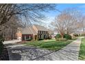 Beautiful brick home featuring a manicured front lawn and a long driveway at 105 Royal Glen Dr, Cary, NC 27518