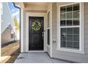 Inviting front entrance with a black door, decorative wreath, and sidelight window at 1111 Axelwood Ln, Durham, NC 27703