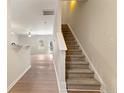 Bright entryway featuring hardwood floors and a staircase leading to the upper level at 3931 Volkswalk Pl, Raleigh, NC 27610