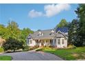 Beautiful single-story home with dormers, metal roof, bay windows, an American flag and a circular driveway at 609 Cashmere Ct, Sanford, NC 27332