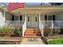 Inviting front porch featuring a white railing, brick steps, and colorful flowerbeds at 609 Cashmere Ct, Sanford, NC 27332