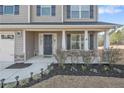 Inviting front porch with decorative columns and professional landscaping leading to the front door at 715 New Castle Ln, Spring Lake, NC 28390