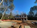 New home under construction showing framing, windows, and wooded surroundings on a sunny day at 96 Peach Orchard (Lot 5) Ln, Lillington, NC 27546