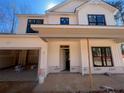 Close up of unfinished exterior elevation with a covered porch and large windows, showcasing modern design at 96 Peach Orchard (Lot 5) Ln, Lillington, NC 27546