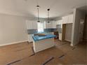 Unfinished modern kitchen with white cabinetry, pendant lighting, and a center island at 96 Peach Orchard (Lot 5) Ln, Lillington, NC 27546