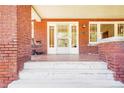 Inviting front porch with brick flooring and a cozy swing, perfect for relaxing outdoors at 205 N Gulf St, Sanford, NC 27330