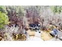 Aerial view of a charming home nestled in a wooded landscape with a long driveway at 2609 Mill Creek Ct, Sanford, NC 27330