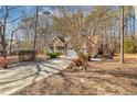 Traditional-style home with an attached garage, well-kept lawn, and mature trees in a serene setting at 6084 Dunes Dr, Sanford, NC 27332