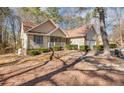 Classic home boasting an attached garage, a cozy front porch, and landscaping set amongst mature trees at 6084 Dunes Dr, Sanford, NC 27332
