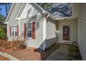 Welcoming front entry featuring red shutters, light-colored siding, and mature landscaping leading to front door at 48 Cedar Ln, Sanford, NC 27332
