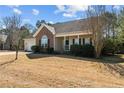 A cozy one-story residence with brick accents, a covered porch, and a well-kept front yard at 59 Claymore Ct, Broadway, NC 27505