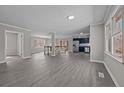 Open concept living room with gray walls, gray flooring and a view of the kitchen at 9349 Perry Rd, Graham, NC 27253