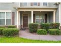 Inviting covered front porch with a solid front door and manicured shrubs at 103 Coopers Creek Ave, Spring Lake, NC 28390
