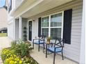 Inviting front porch with a seating area and well maintained landscaping at 15 Summerwood Ln, Lillington, NC 27546